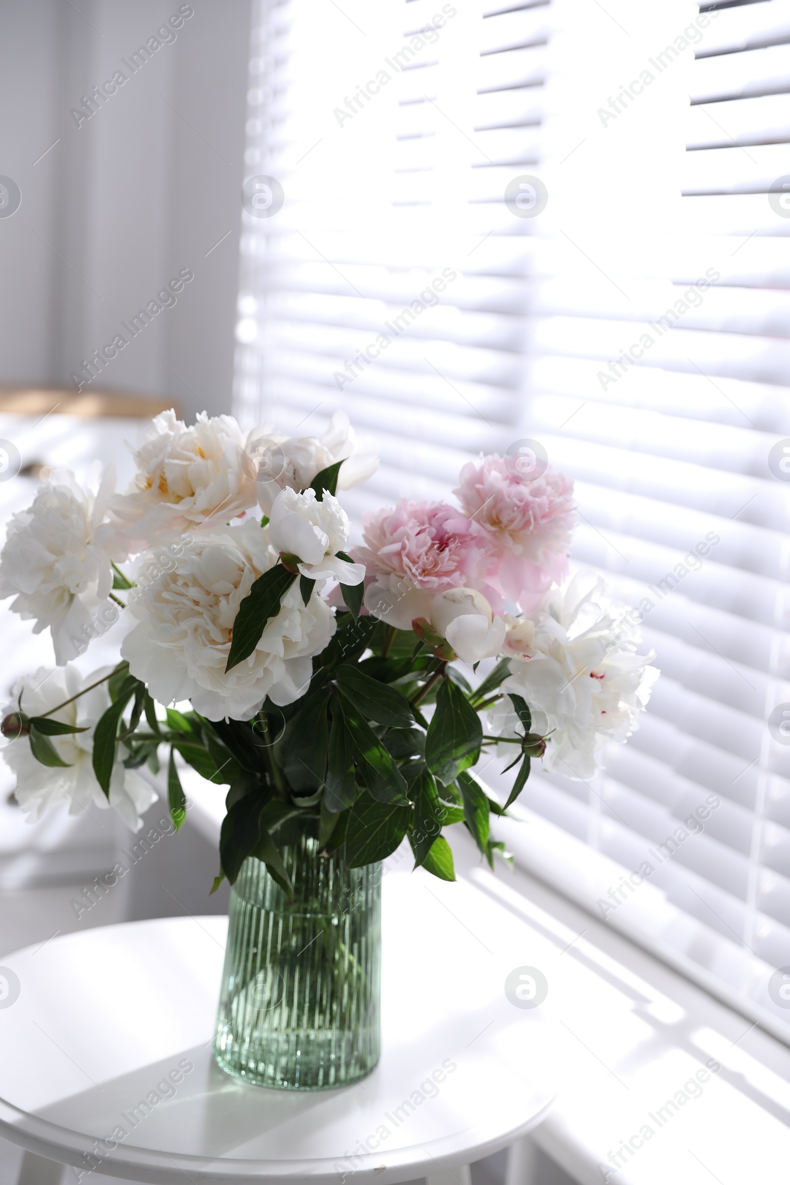 Photo of Bouquet of beautiful peony flowers on table indoors