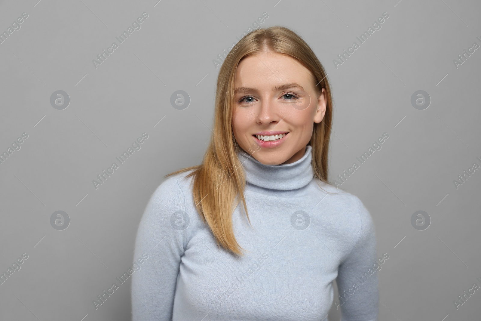 Photo of Portrait of beautiful young woman on grey background