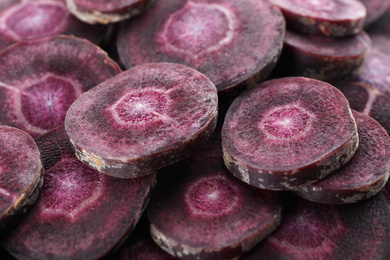 Slices of raw purple carrot as background, closeup