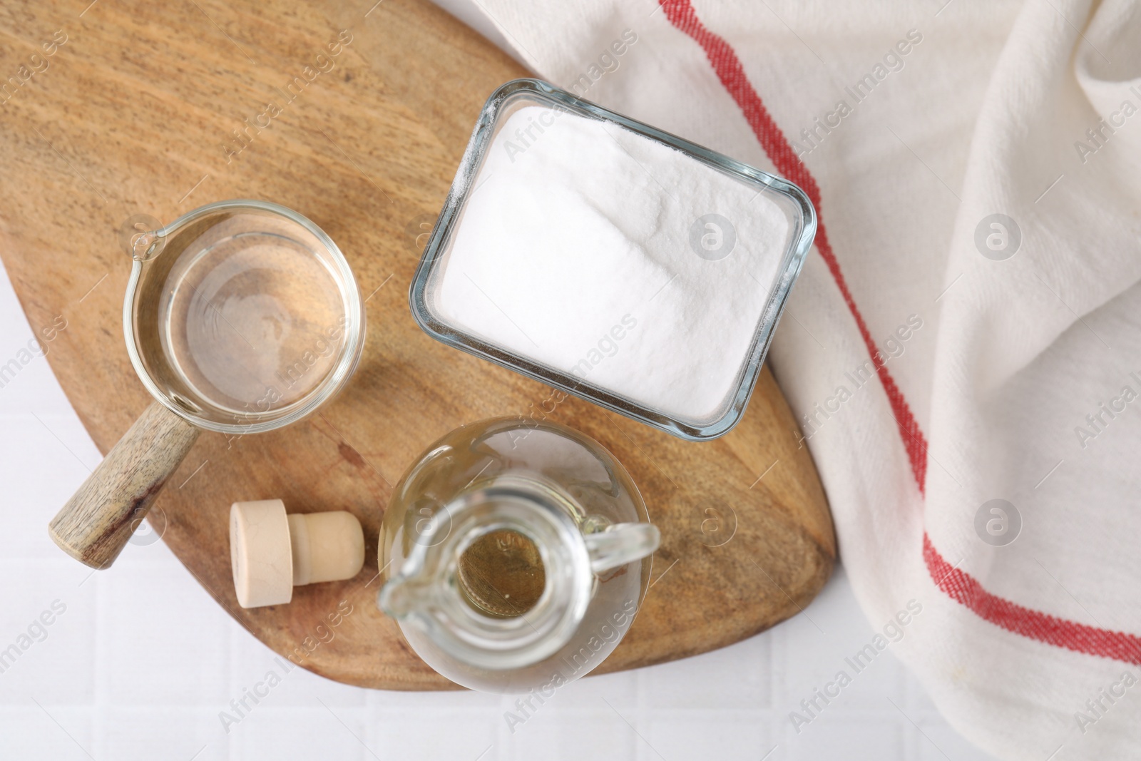 Photo of Vinegar and baking soda on white tiled table, top view