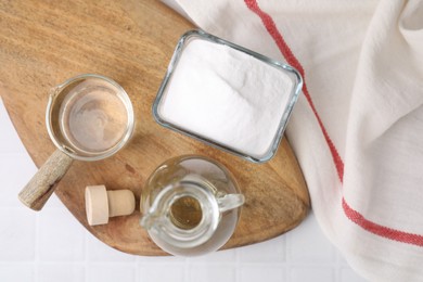 Vinegar and baking soda on white tiled table, top view