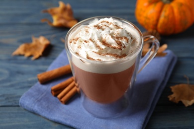 Delicious pumpkin latte on blue wooden table, closeup