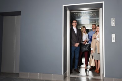 Photo of Group of office workers in modern elevator