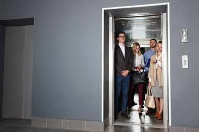 Group of office workers in modern elevator