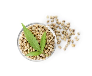 Bowl of hemp seeds with green leaf on white background, top view