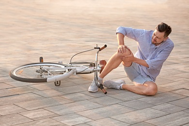 Man fallen off his bicycle on street