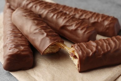 Photo of Sweet tasty chocolate bars with caramel on grey table, closeup