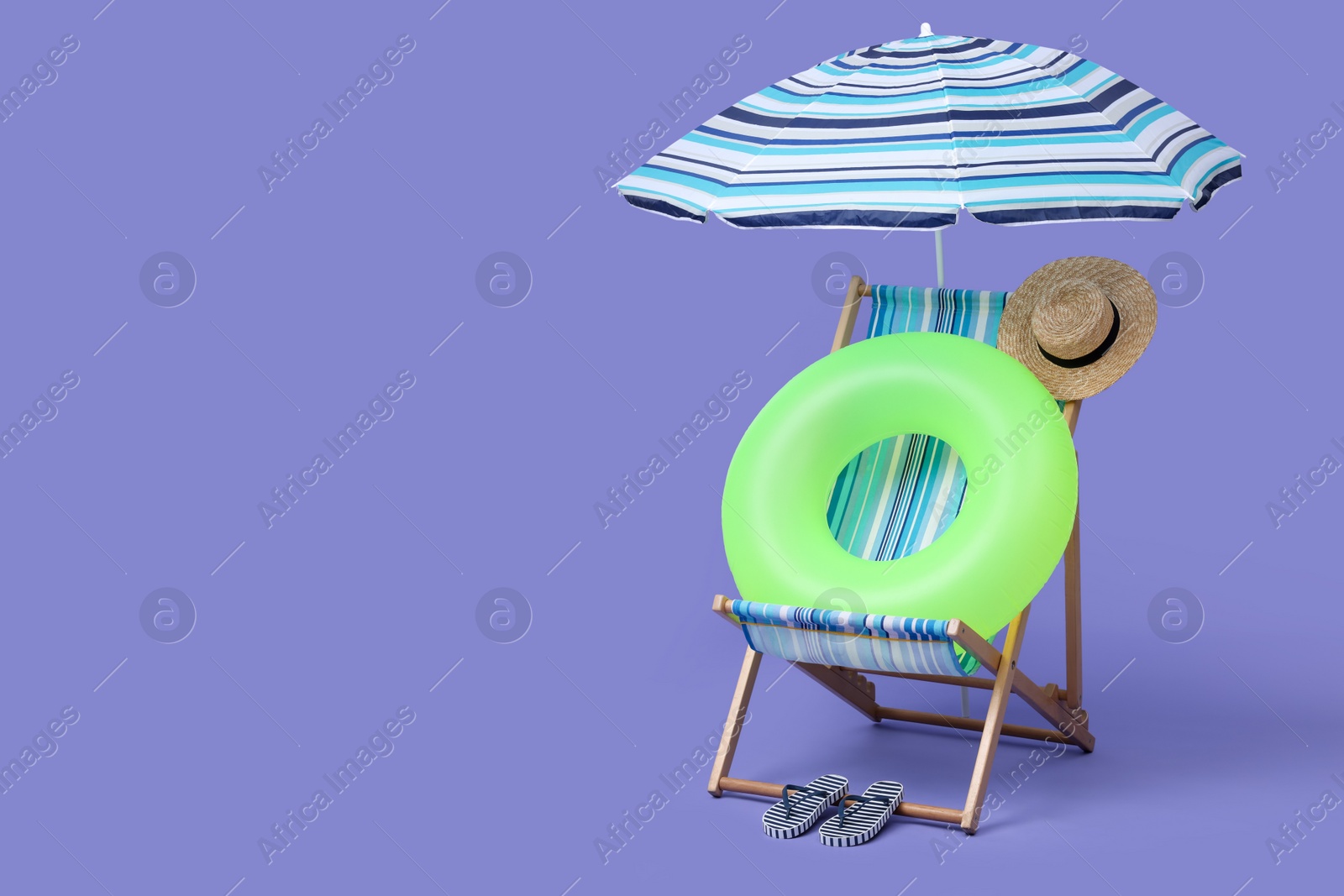 Deck chair, umbrella and other beach accessories on purple background, space for text. Summer vacation Photo of Deck chair, umbrella and other beach accessories on purple background, space for text. Summer vacation