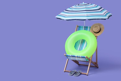 Photo of Deck chair, umbrella and other beach accessories on purple background, space for text. Summer vacation