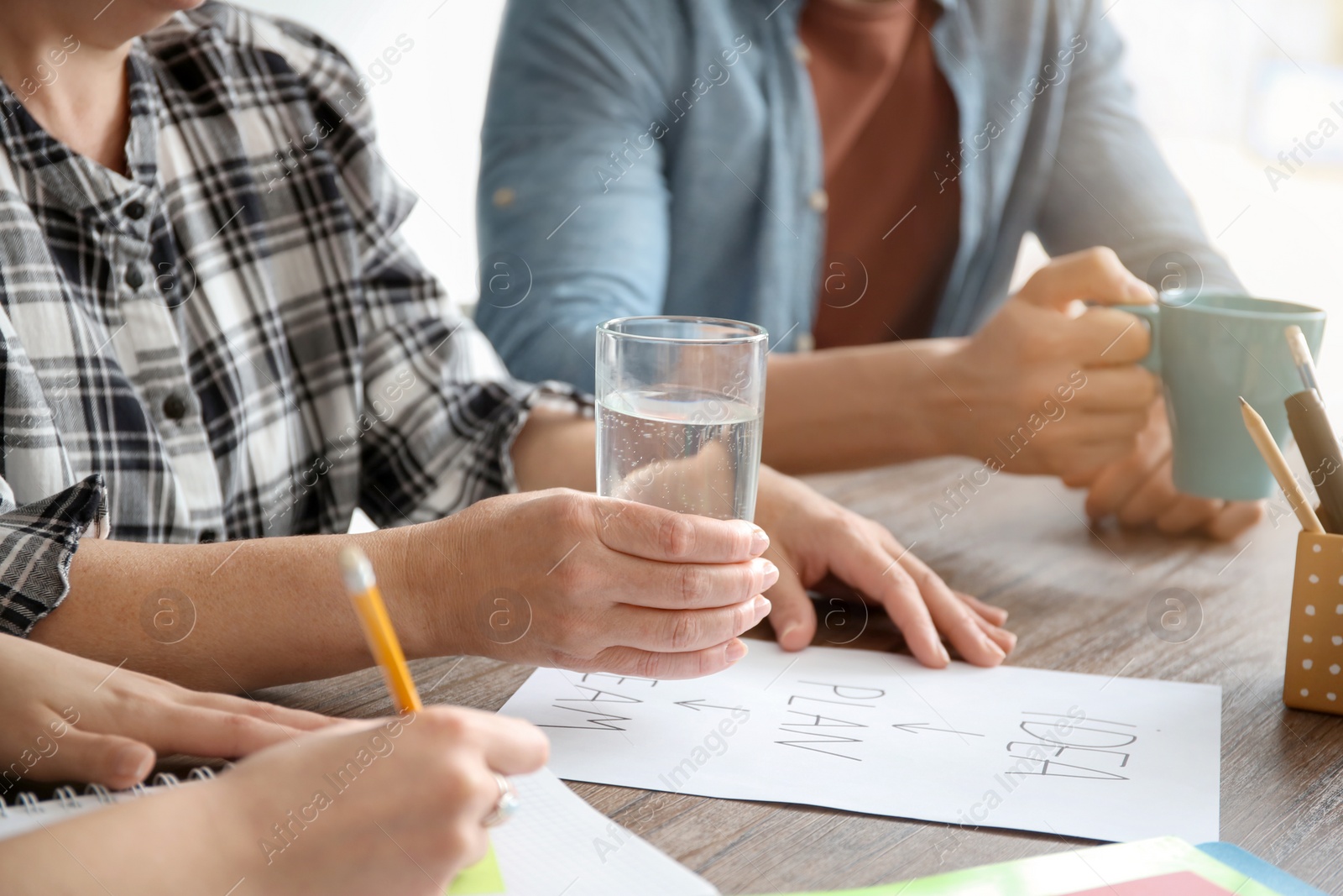 Photo of People working at table, closeup of hands. Unity concept