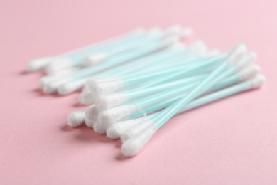 Photo of Pile of cotton swabs on color background, closeup