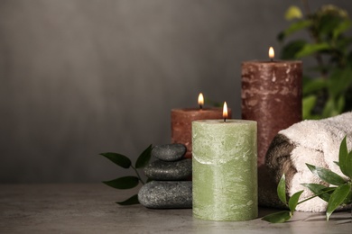 Composition with candles and spa stones on grey table. Space for text