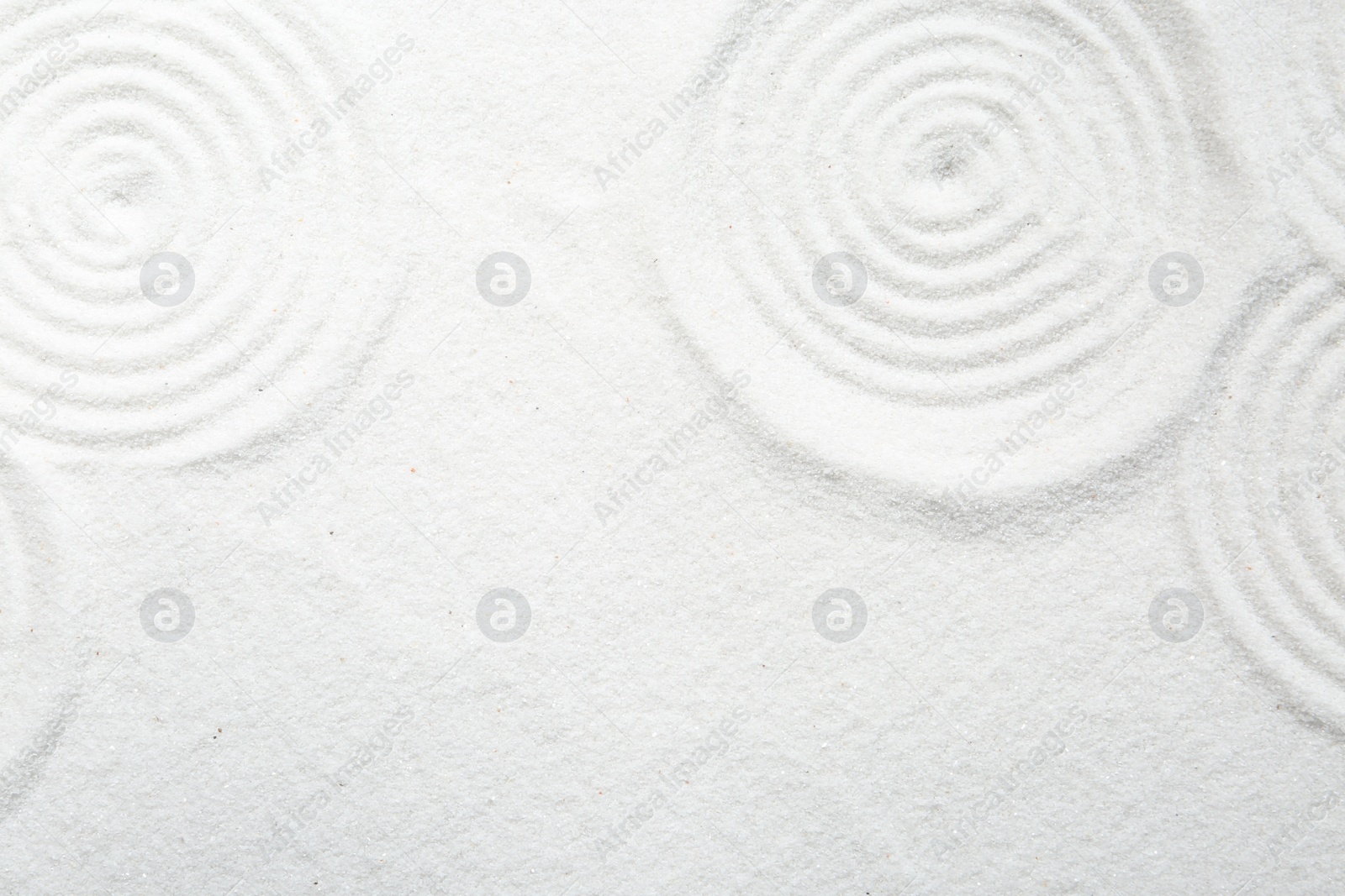 Photo of Zen rock garden. Circle patterns on white sand, top view