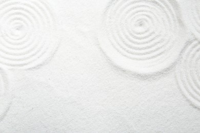 Photo of Zen rock garden. Circle patterns on white sand, top view