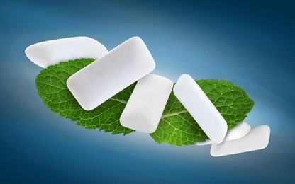 Image of Fresh mint leaves and chewing gum pads flying on blue background