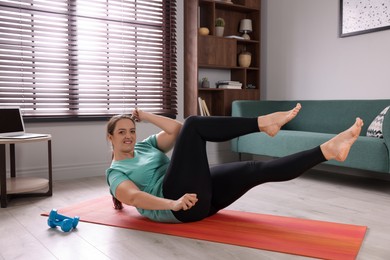 Photo of Overweight woman doing abs exercise on yoga mat at home