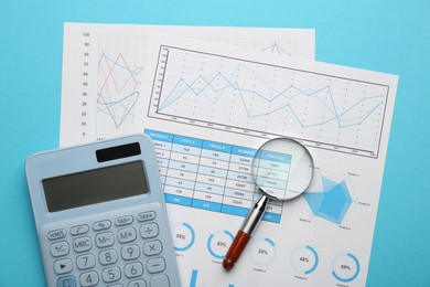 Photo of Accounting documents, magnifying glass and calculator on light blue background, top view