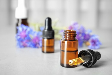 Photo of Composition with essential oil and flowers on table