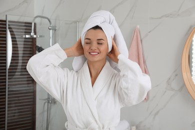 Photo of Beautiful young woman with hair wrapped in towel indoors
