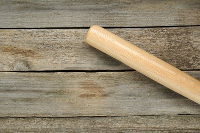 Photo of Baseball bat on wooden table, top view with space for text. Sports equipment