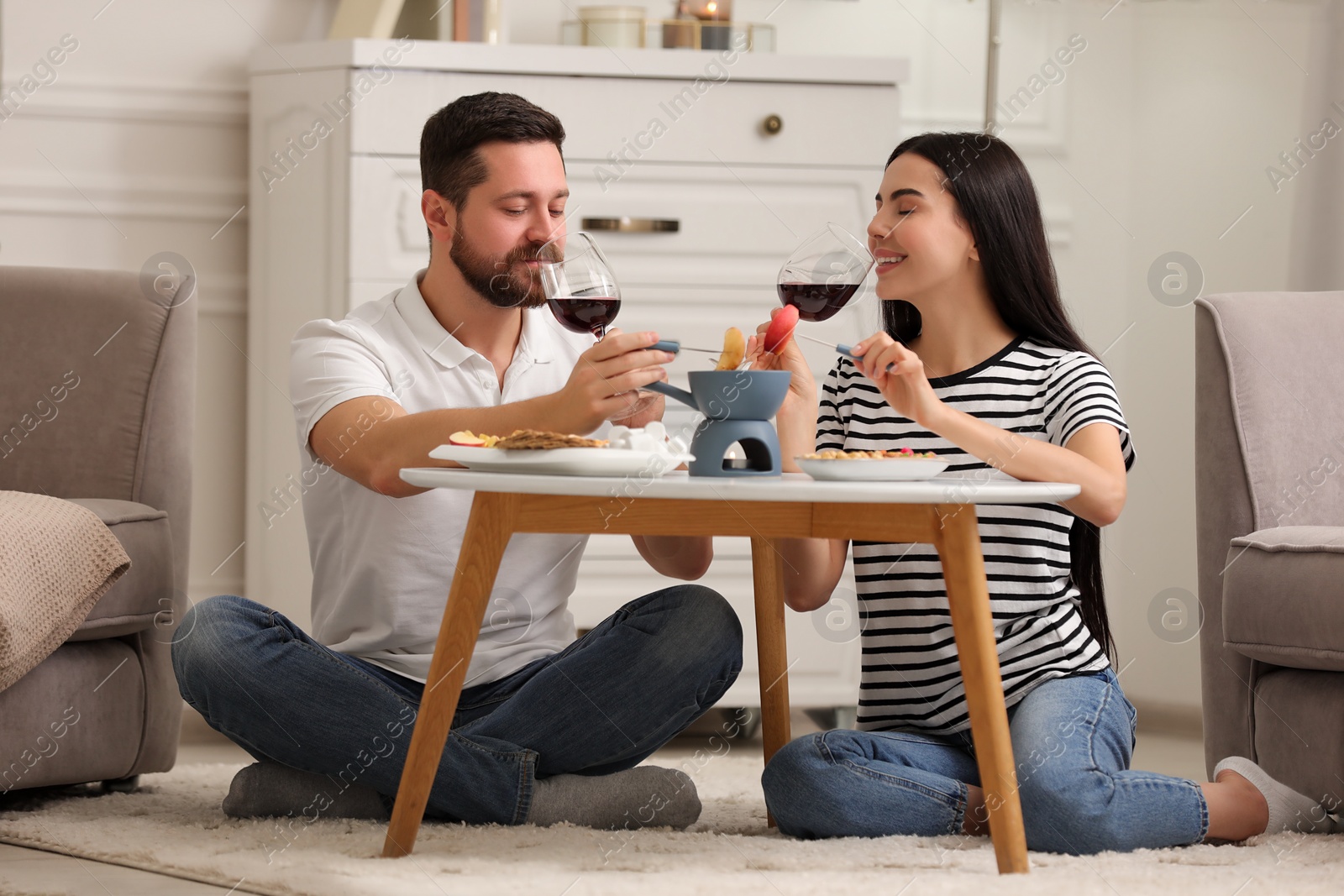 Photo of Affectionate couple enjoying fondue during romantic date at home