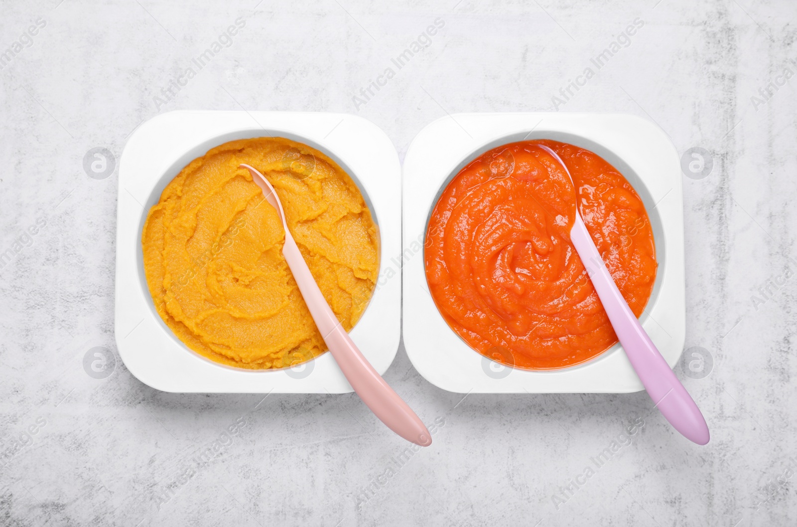 Photo of Containers with healthy baby food and spoons on white textured table, flat lay