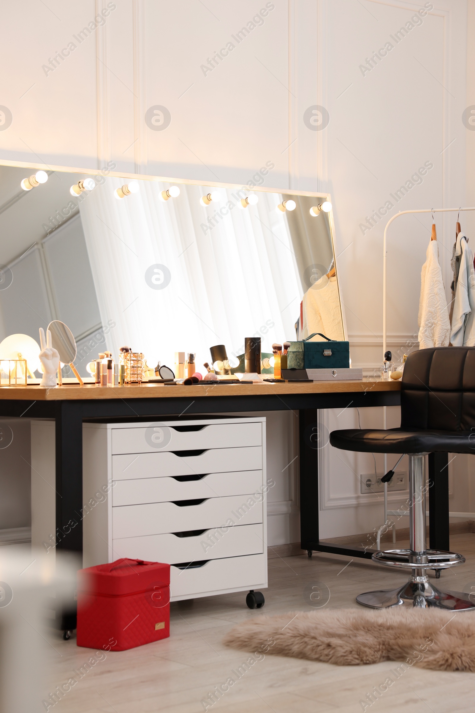 Photo of Makeup room. Stylish dressing table with mirror and chair