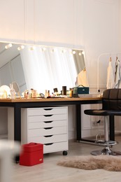 Photo of Makeup room. Stylish dressing table with mirror and chair
