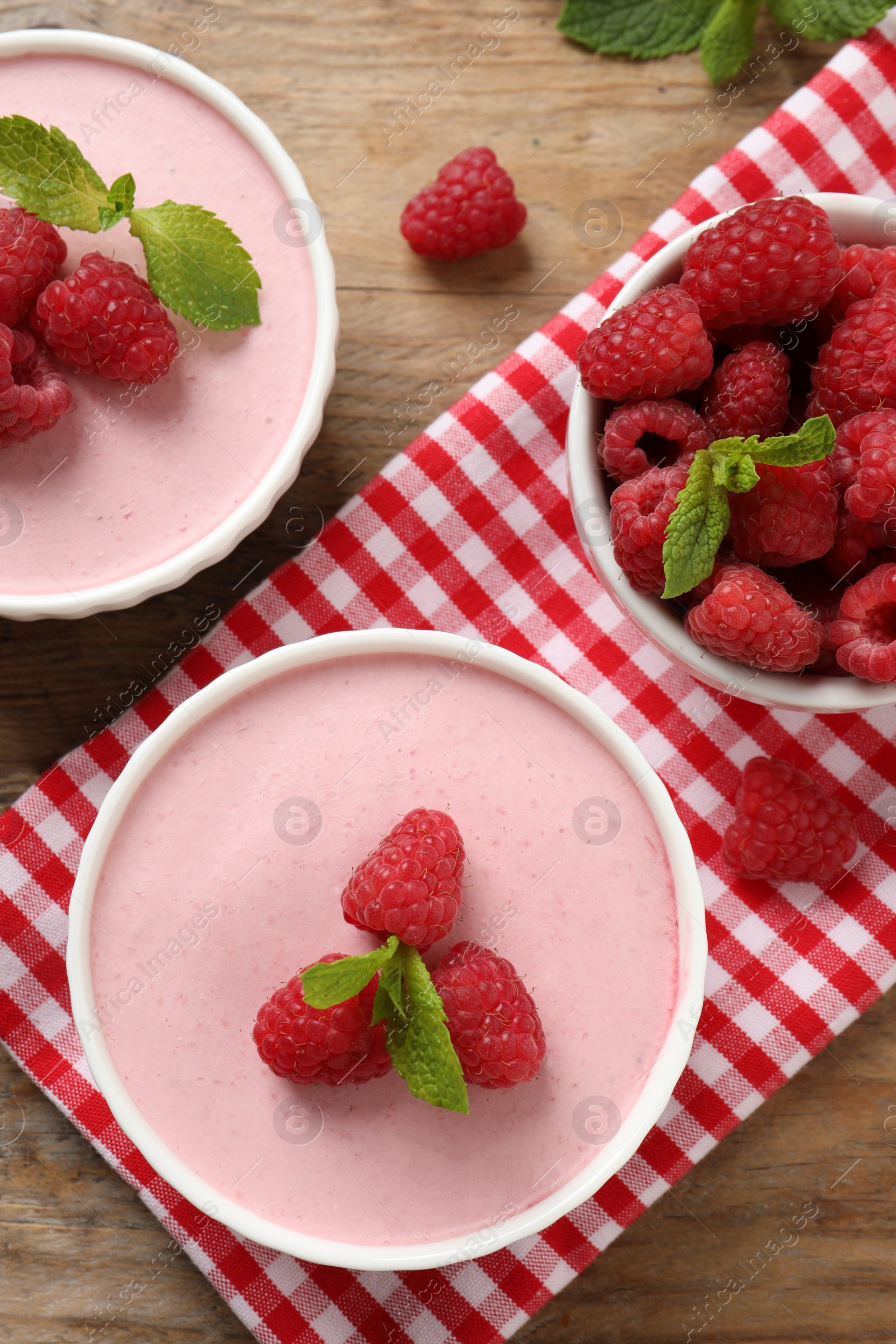 Photo of Delicious raspberry mousse with mint on wooden table, flat lay