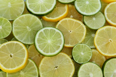 Photo of Fresh ripe lemons and limes as background, top view