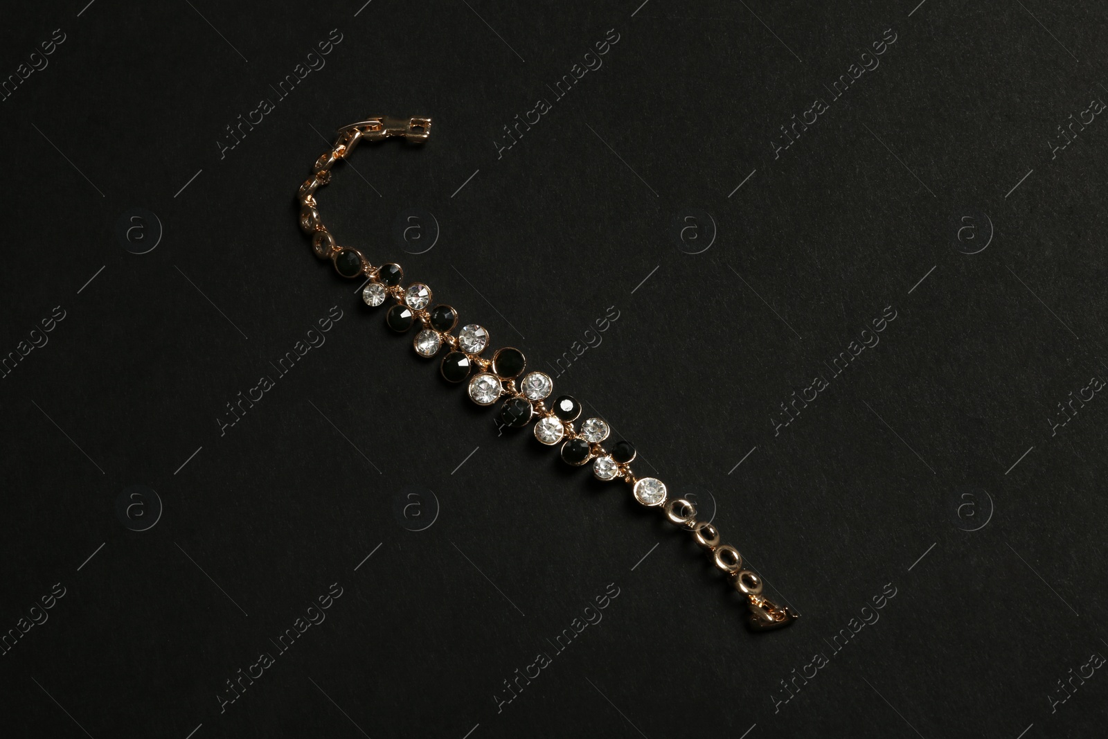 Photo of Stylish bracelet with gemstones on black background. Luxury jewelry