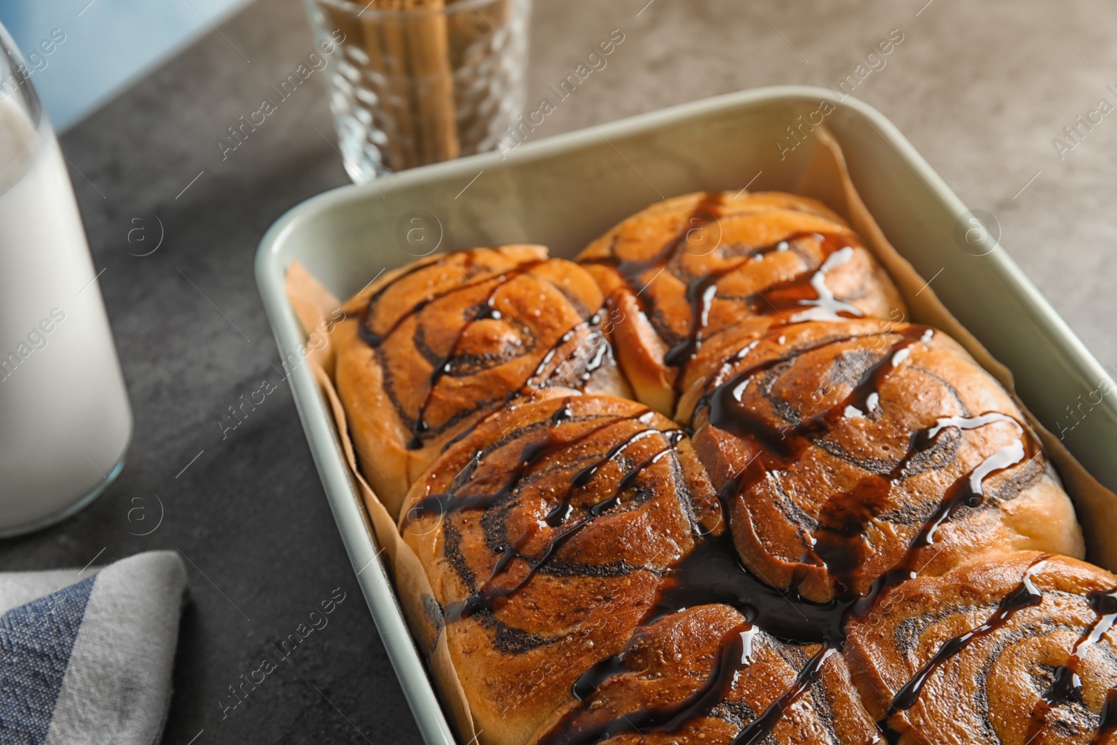 Photo of Baking dish with cinnamon rolls on table, closeup