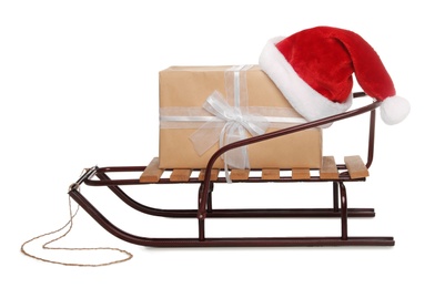 Photo of Sleigh with gift box and Santa hat isolated on white