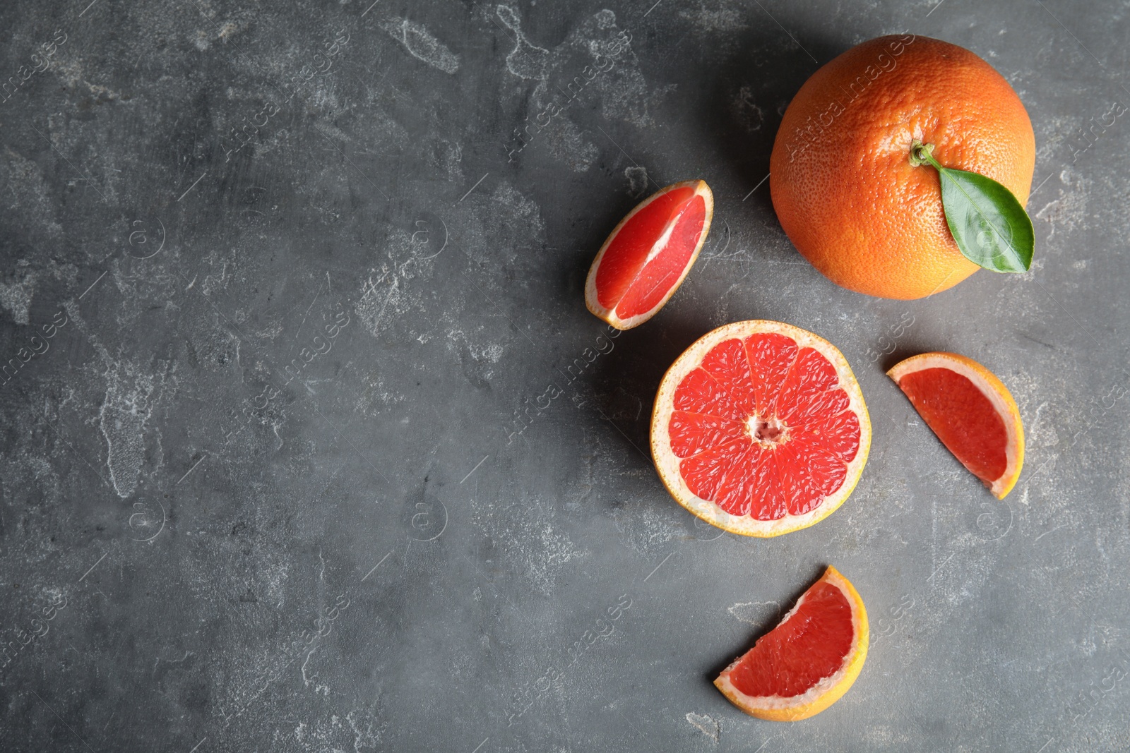 Photo of Fresh tasty grapefruits on grey background, top view with space for text