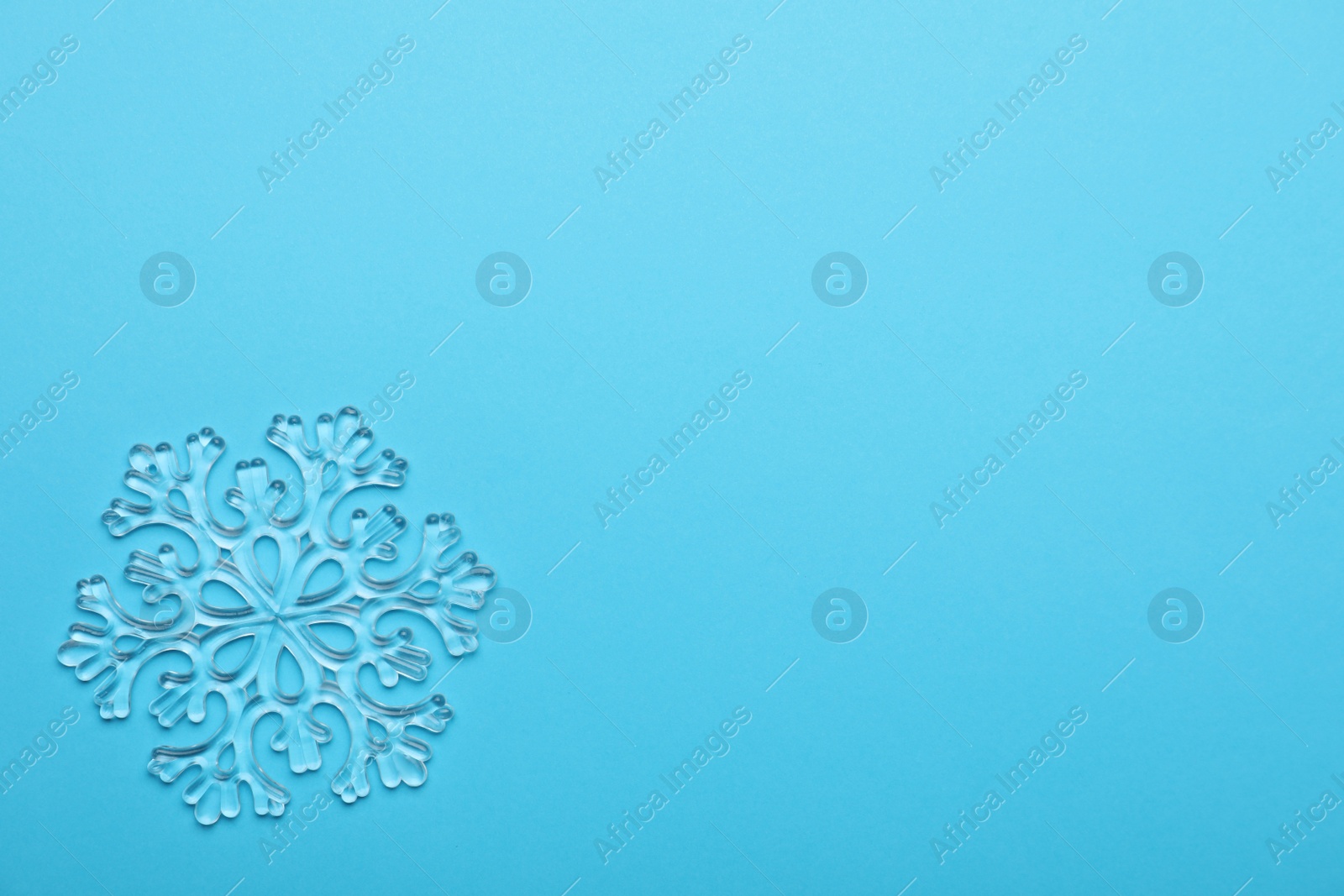 Photo of Beautiful decorative snowflake on light blue background, top view. Space for text
