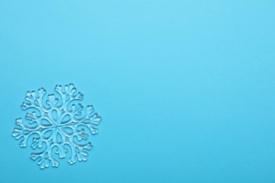 Photo of Beautiful decorative snowflake on light blue background, top view. Space for text