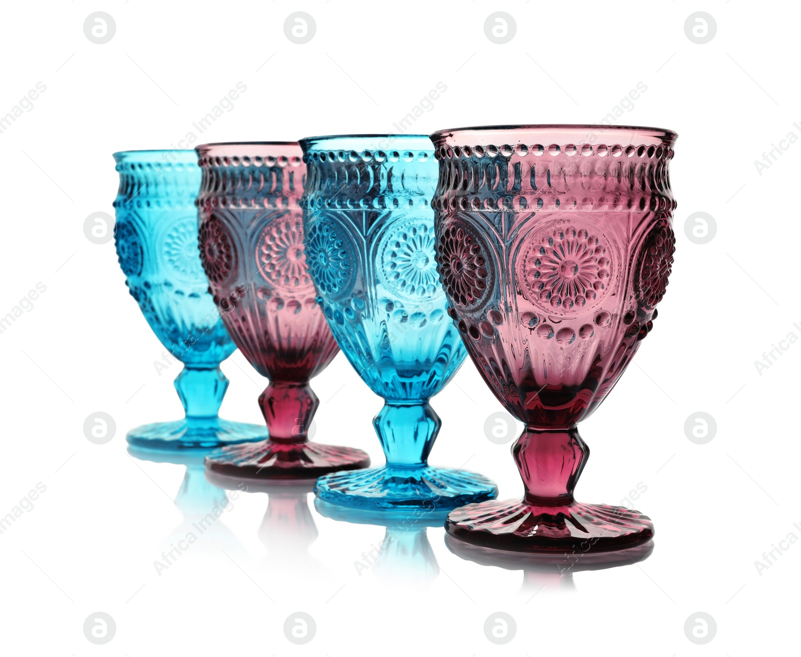 Photo of Empty elegant colorful glasses on white background