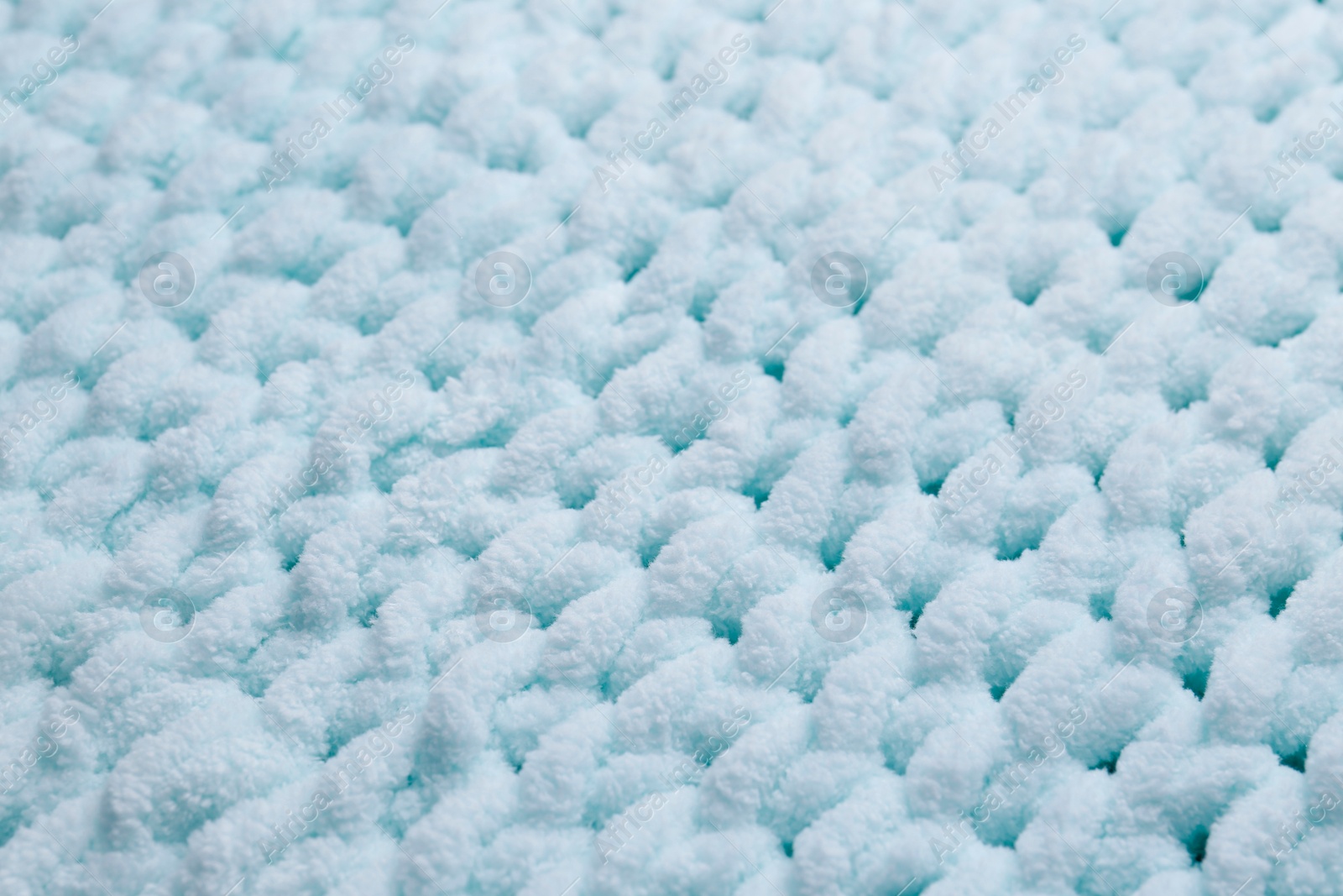 Photo of Soft light blue knitted fabric as background, closeup