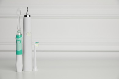 Electric toothbrushes on white background, space for text