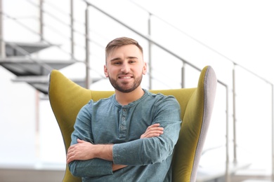 Portrait of confident young man in armchair