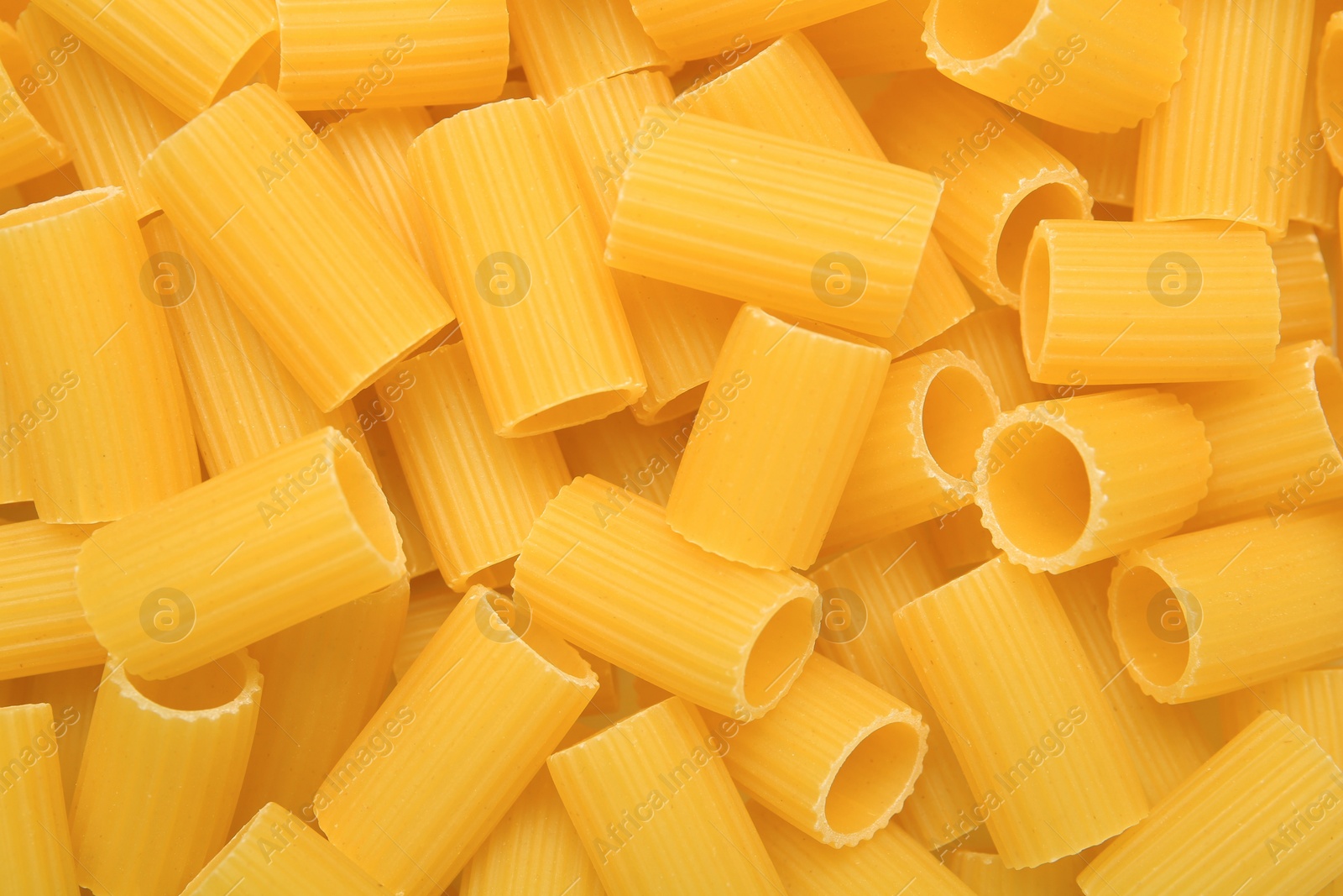 Photo of Raw rigatoni pasta as background, top view