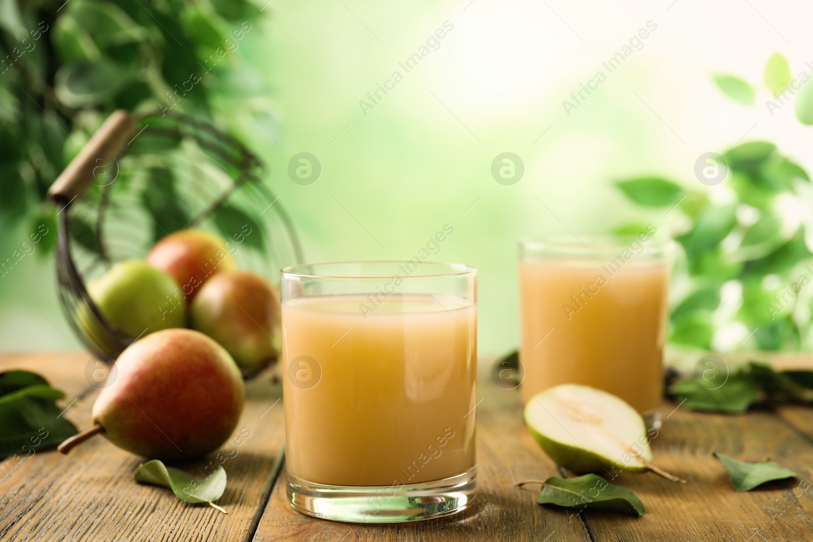 Photo of Fresh pear juice in glass on wooden table, closeup