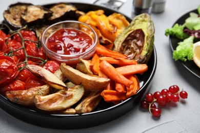 Photo of Tasty cooked vegetables served on grey table, closeup. Healthy meals from air fryer
