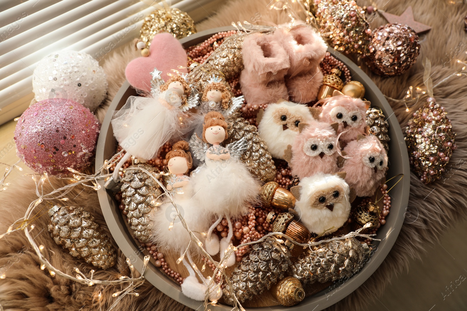 Photo of Beautiful Christmas tree baubles, toys and fairy lights on window sill, above view