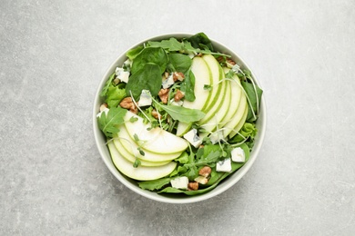 Tasty salad with pear slices on light grey table, top view