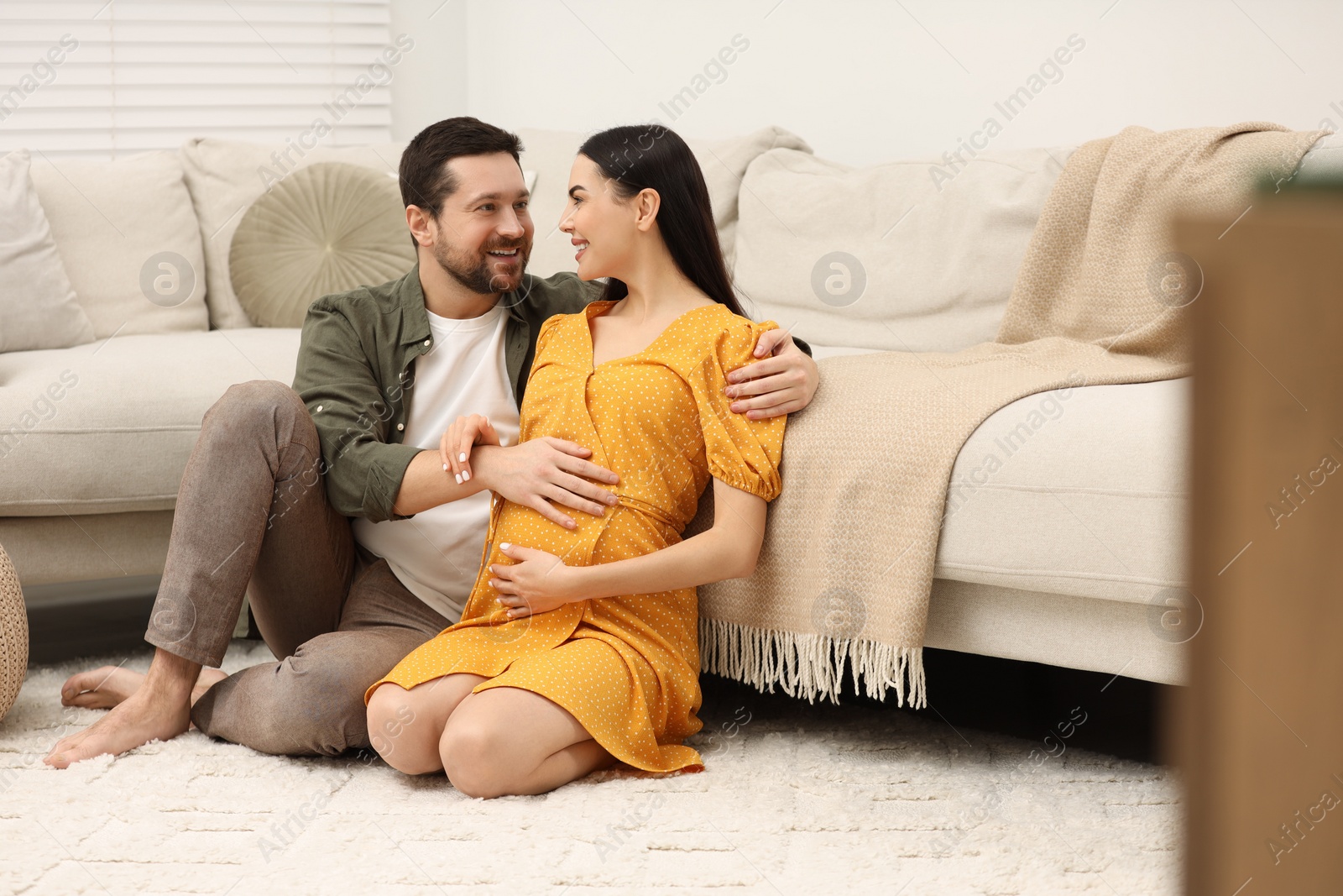 Photo of Happy pregnant woman spending time with her husband at home