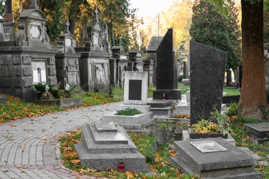 Photo of Many tombstones and paved footpath at cemetery