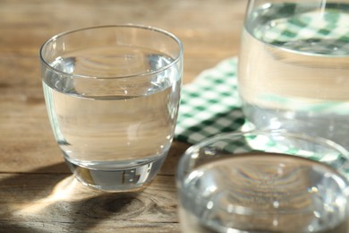 Photo of Glasses of water on wooden table. Refreshing drink