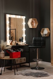 Photo of Makeup room. Stylish mirror near dressing table with beauty products and chair indoors