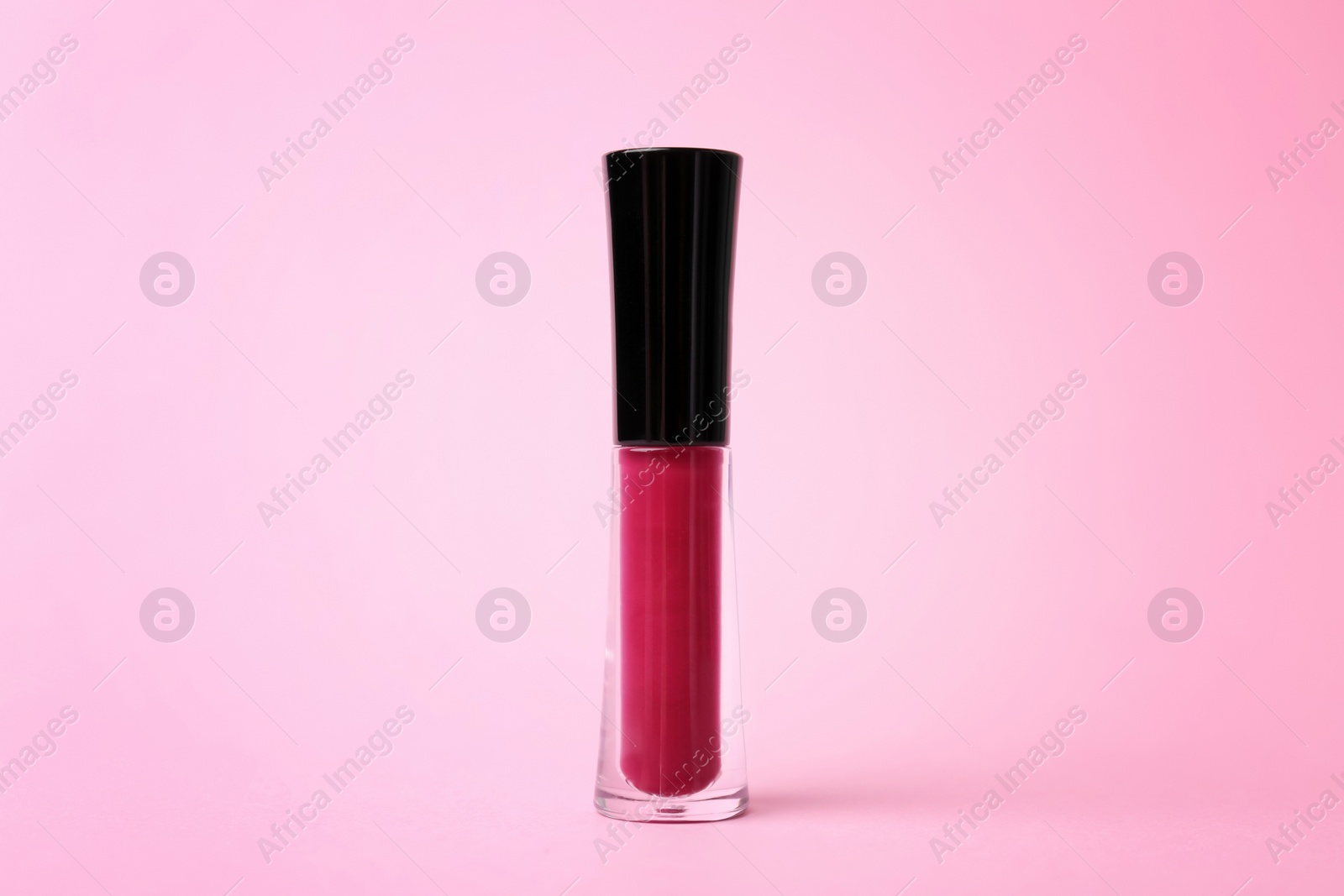 Photo of Beautiful lip gloss on color background